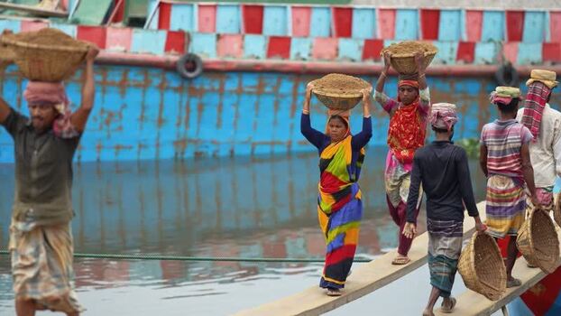 View of workers carrying sand baskets in Aminbazar Bangladesh. View of workers carrying sand baskets in Aminbazar Bangladesh.