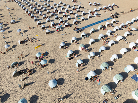 Figueira da Foz Portugal 08 August 2024 Aerial view of Praia da Figueira da Foz Praia do Relogio with numerous white beach tents and striped umbrellas arranged on the sand with people relaxing. Figueira da Foz Portugal 08 August 2024 Aerial view of Praia da Figueira da Foz Praia do Relogio with numerous white beach tents and striped umbrellas arranged on the sand with people relaxing.