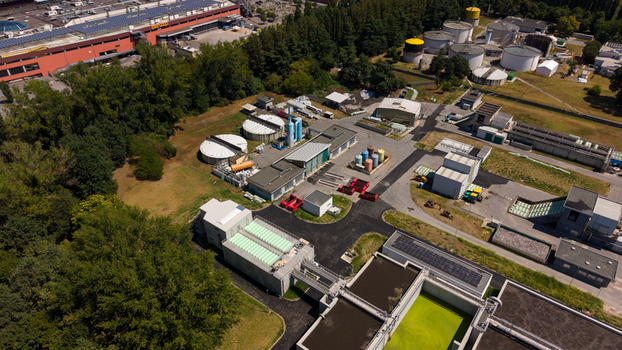 Aerial view of a wastewater treatment plant featuring circular sedimentation tanks green water basins and industrial buildings Milan Lombardy Italy. Aerial view of a wastewater treatment plant featuring circular sedimentation tanks green water basins and industrial buildings Milan Lombardy Italy.
