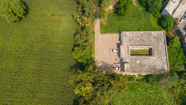 Lahore Pakistan 08 September 2026 Aerial view of the Government Officers building with a central courtyard surrounded by lush green fields and trees.