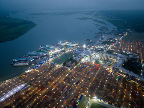 Aerial view of the illuminated market stretching towards the riverbank where boats dock under the fading light Charmonai Barisal Division Bangladesh. Aerial view of the illuminated market stretching towards the riverbank where boats dock under the fading light Charmonai Barisal Division Bangladesh.