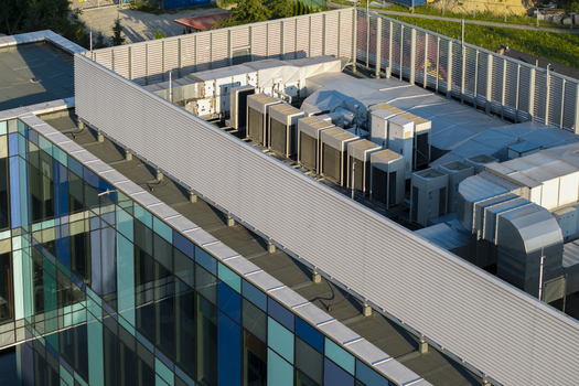 Aerial view of the rooftop of an AI data center featuring multiple HVAC units and ventilation systems on a modern building with a glass facade in Krakow Lesser Poland Voivode Poland. Aerial view of the rooftop of an AI data center featuring multiple HVAC units and ventilation systems on a modern building with a glass facade in Krakow Lesser Poland Voivode Poland.