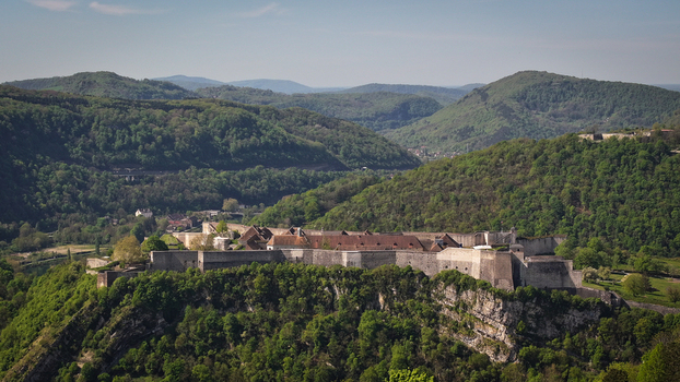 Aerial view of Besancon Citadel with its historic stone walls and defensive fortifications surrounded by lush green forested hills in Besancon Bourgogne Franche Comte France. Aerial view of Besancon Citadel with its historic stone walls and defensive fortifications surrounded by lush green forested hills in Besancon Bourgogne Franche Comte France.