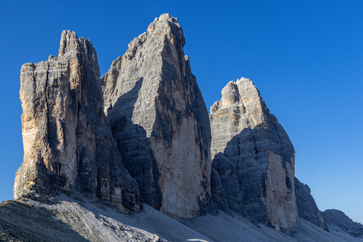 View of Tre Cime di Lavaredo with its iconic jagged limestone peaks rising against a clear blue sky in Auronzo di Cadore Veneto Italy.