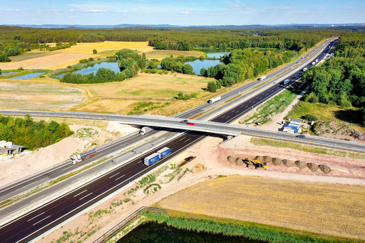 Nuremberg Germany 18 May 2024 Aerial view of the A73 motorway with trucks and cars driving through a landscape of green forests fields and small ponds. Nuremberg Germany 18 May 2024 Aerial view of the A73 motorway with trucks and cars driving through a landscape of green forests fields and small ponds.