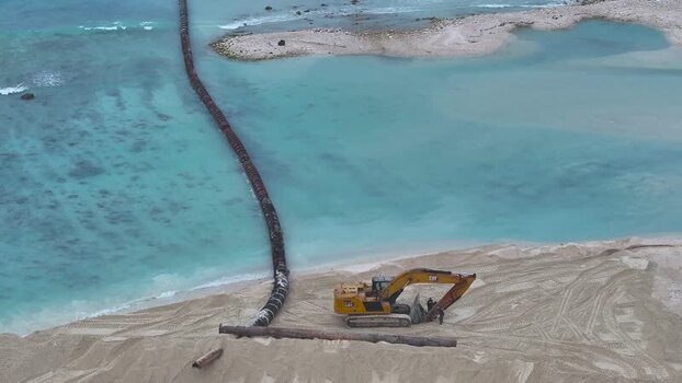 Aerial view of an excavator working on a beach pipeline Maldives.