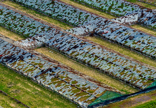 Aerial view of dilapidated greenhouses with broken glass panels and mossy roofs in an abandoned industrial farm Vilnius County Lithuania. Aerial view of dilapidated greenhouses with broken glass panels and mossy roofs in an abandoned industrial farm Vilnius County Lithuania.