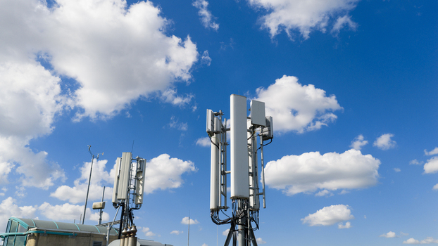 Aerial view of telecommunication antennas and wireless communication equipment on a rooftop under a blue cloudy sky in Amsterdam North Holland Netherlands. Aerial view of telecommunication antennas and wireless communication equipment on a rooftop under a blue cloudy sky in Amsterdam North Holland Netherlands.