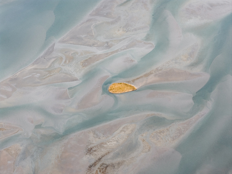Aerial view of the tidal flats and sandbanks surrounding the island of Senja with intricate patterns of water and sediment in the coastal landscape of Senja Troms Norway.