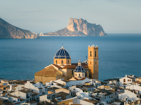Aerial view of the Church of Our Lady of Consolation with iconic blue tiled domes overlooking the Mediterranean Sea and Penyal d Ifac in Altea Valencian Community Spain.