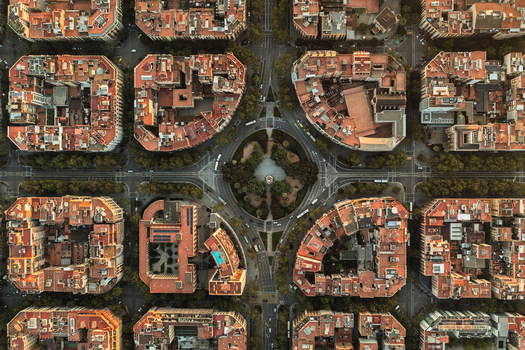 Aerial view of the Eixample district in Barcelona showcasing the iconic grid layout octagonal city blocks with inner courtyards and a central roundabout Barcelona Catalonia Spain.