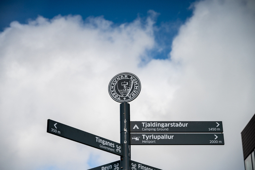 View of a signpost with the Torshavnar Kommuna emblem indicating directions to Tinganes the camping ground and the heliport in Faroe Islands. View of a signpost with the Torshavnar Kommuna emblem indicating directions to Tinganes the camping ground and the heliport in Faroe Islands.