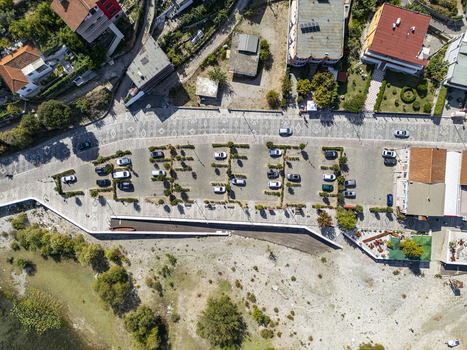 Aerial view of the parking area along the promenade in Shiroke with parked cars paved surfaces and nearby buildings overlooking the lake in Shiroke Qarku i Shkodres Albania. Aerial view of the parking area along the promenade in Shiroke with parked cars paved surfaces and nearby buildings overlooking the lake in Shiroke Qarku i Shkodres Albania.