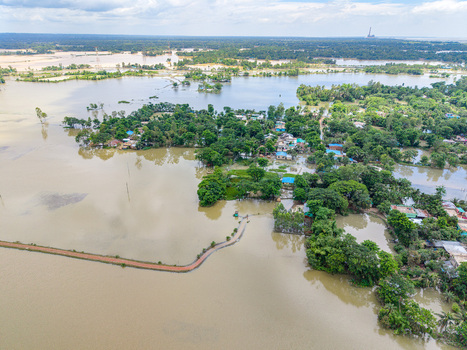 Aerial view of flooded residential areas and lush vegetation surrounded by extensive floodwaters in Banshkhali Upazila Chittagong Division Bangladesh. Aerial view of flooded residential areas and lush vegetation surrounded by extensive floodwaters in Banshkhali Upazila Chittagong Division Bangladesh.