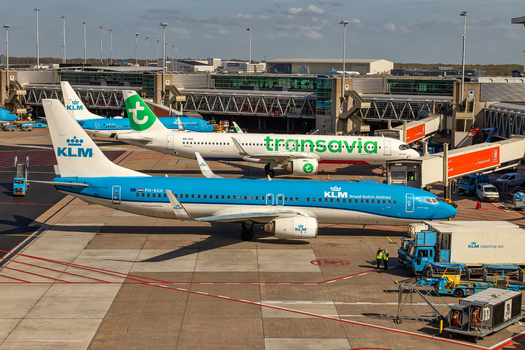 Schiphol Netherlands 16 April 2026 View of KLM and Transavia airplanes parked at the terminal gates of Schiphol Airport with ground service vehicles and airport infrastructure under a clear sky. Schiphol Netherlands 16 April 2026 View of KLM and Transavia airplanes parked at the terminal gates of Schiphol Airport with ground service vehicles and airport infrastructure under a clear sky.