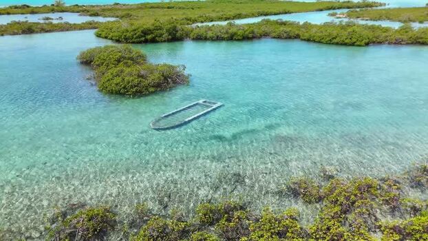 Aerial view of a sunken boat in turquoise water The Bahamas.