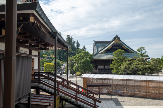 View of traditional Japanese architecture featuring dark wood intricate roofs and lush greenery under a cloudy sky creating a serene atmosphere Narita Chiba Japan. View of traditional Japanese architecture featuring dark wood intricate roofs and lush greenery under a cloudy sky creating a serene atmosphere Narita Chiba Japan.