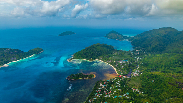 Aerial view of the turquoise waters and lush green hills of the coastal landscape Cap Ternay Port Glaud Seychelles. Aerial view of the turquoise waters and lush green hills of the coastal landscape Cap Ternay Port Glaud Seychelles.