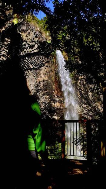 View of a person observing a waterfall in Raglan New Zealand.