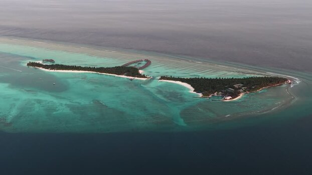 Aerial view of a tropical island and coral reefs Maldives.