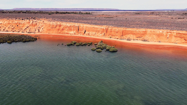 Aerial view of the red cliffs of the Matthew Flinders Red Cliff Lookout meeting the calm waters of the Spencer Gulf Port Augusta West South Australia Australia. Aerial view of the red cliffs of the Matthew Flinders Red Cliff Lookout meeting the calm waters of the Spencer Gulf Port Augusta West South Australia Australia.