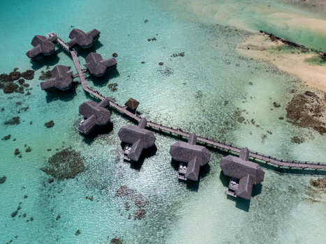 Tikehau French Polynesia 11 September 2026 Aerial view of Le Tikehau by Pearl Resorts with overwater bungalows connected by a wooden walkway over the turquoise lagoon.