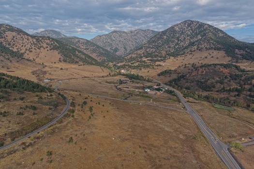 Aerial view of the mountainous landscape featuring winding roads dry grassy plains and the foothills of the Rocky Mountains in Golden Colorado United States.