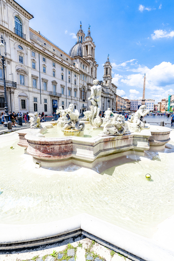 View of the Fountain of the Moor with its intricate marble sculptures in Piazza Navona under a bright blue sky in Rome Lazio Italy. View of the Fountain of the Moor with its intricate marble sculptures in Piazza Navona under a bright blue sky in Rome Lazio Italy.