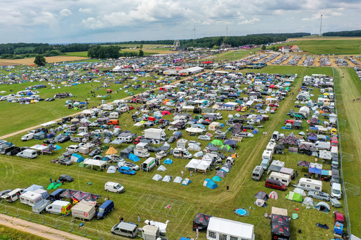Aerial view of the Open Beatz Festival camping area with rows of tents and camper vans parked on a large green field Herzogenaurach Bayern Germany. Aerial view of the Open Beatz Festival camping area with rows of tents and camper vans parked on a large green field Herzogenaurach Bayern Germany.
