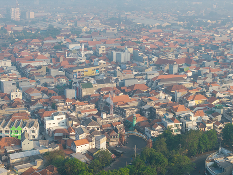 Genteng Indonesia 13 August 2026 Aerial view of Surabaya Old Town with dense historic red tiled rooftops narrow streets and traditional architecture under a hazy sky. Genteng Indonesia 13 August 2026 Aerial view of Surabaya Old Town with dense historic red tiled rooftops narrow streets and traditional architecture under a hazy sky.