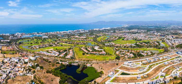 Panoramic view of the tourist area featuring a vast golf course whose lush green contrasts with the blue of the ocean Riviera Nayarit Mexico