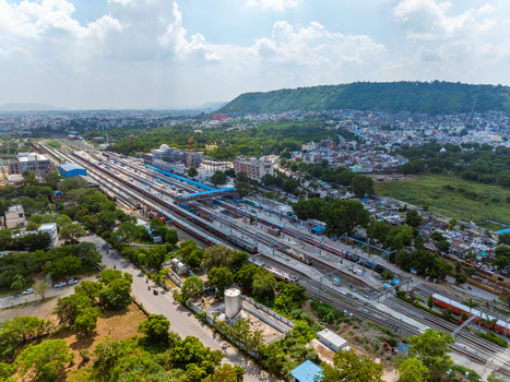 Aerial view of the railway station with trains on tracks and platforms amidst the urban landscape of Udaipur Rajasthan India. Aerial view of the railway station with trains on tracks and platforms amidst the urban landscape of Udaipur Rajasthan India.
