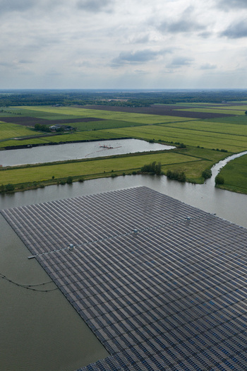 Aerial view of a large floating solar farm on a lake surrounded by green agricultural fields and a canal in Beilen Drenthe Netherlands. Aerial view of a large floating solar farm on a lake surrounded by green agricultural fields and a canal in Beilen Drenthe Netherlands.
