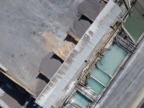 Aerial view of an industrial facility featuring metal rooftops piles of gravel and large water treatment tanks in Kilsyth Victoria Australia. Aerial view of an industrial facility featuring metal rooftops piles of gravel and large water treatment tanks in Kilsyth Victoria Australia.