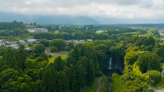 Aerial view of Shiraito Falls surrounded by lush green forest and trees in Japan. Aerial view of Shiraito Falls surrounded by lush green forest and trees in Japan.