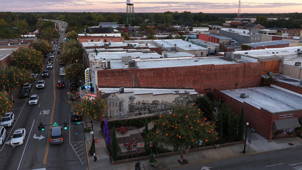 Aerial view of the historic downtown area of Conway featuring a large mural on a brick building a theater and tree lined streets at sunset in Conway South Carolina United States. Aerial view of the historic downtown area of Conway featuring a large mural on a brick building a theater and tree lined streets at sunset in Conway South Carolina United States.