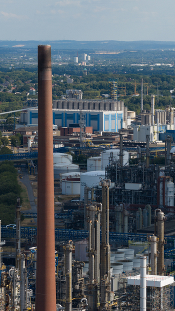 Aerial view of the Tanklager industrial facility featuring tall chimneys storage tanks and complex refinery infrastructure in Gelsenkirchen North Rhine Westphalia Germany.