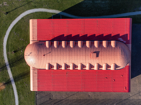 Aerial view of a building with a striking red roof casting long shadows on the green lawn 7 Adriaen Blockstraat Almere Flevoland Netherlands. Aerial view of a building with a striking red roof casting long shadows on the green lawn 7 Adriaen Blockstraat Almere Flevoland Netherlands.