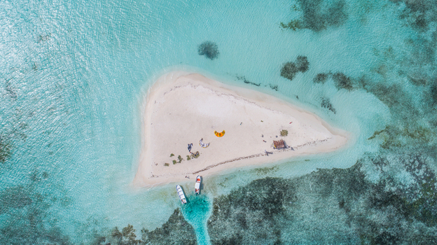 Aerial view of Los Roques archipelago featuring a sandy cay in turquoise Caribbean waters with moored boats and kitesurfing gear Los Roques Dependencias Federales Venezuela. Aerial view of Los Roques archipelago featuring a sandy cay in turquoise Caribbean waters with moored boats and kitesurfing gear Los Roques Dependencias Federales Venezuela.