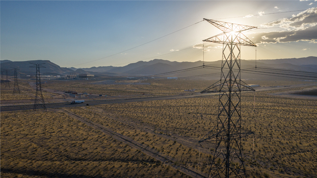 Aerial view of high voltage power lines and transmission towers stretching across a desert landscape with mountains in the background Enterprise Nevada United States. Aerial view of high voltage power lines and transmission towers stretching across a desert landscape with mountains in the background Enterprise Nevada United States.