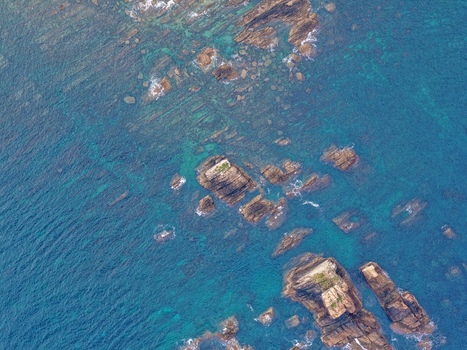 Aerial view of the jagged rock formations and turquoise waters near Silence Beach Viewpoint in Cudillero Asturias Spain.
