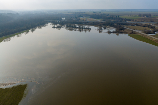 Aerial view of flooded fields and bare trees under a hazy sky near a distant road in Kaniukai Kaunas County Lithuania. Aerial view of flooded fields and bare trees under a hazy sky near a distant road in Kaniukai Kaunas County Lithuania.