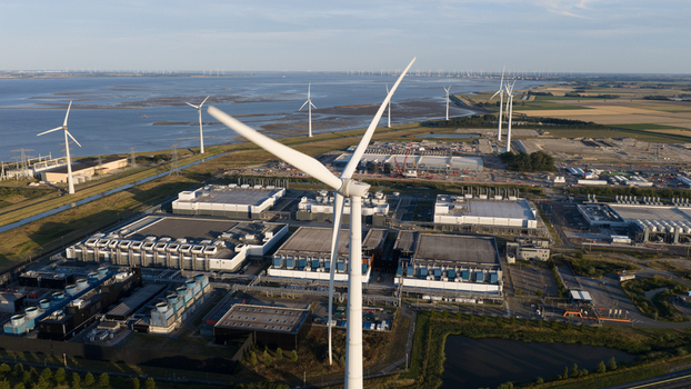 Aerial view of wind turbines and a large data center complex situated in the industrial landscape of Eemshaven Groningen Netherlands.