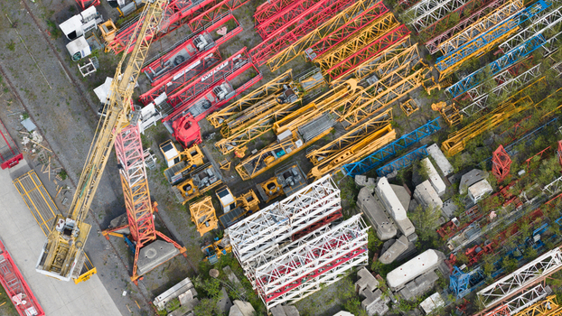 Aerial view of Feluy de Parc Industriel showing a dense storage yard filled with colorful tower crane lattice sections and heavy construction equipment Seneffe Region wallonne Belgium.