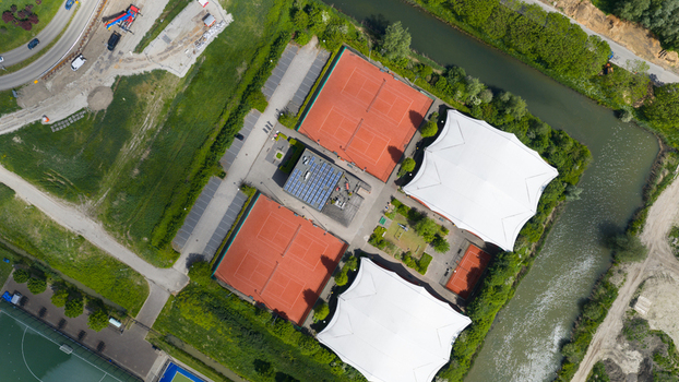 Aerial view of H.C. Rijnvliet sports complex featuring red courts a parking lot and a canal surrounded by green trees in Utrecht Utrecht Netherlands.