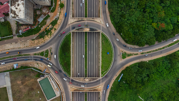 Accra Ghana 02 June 2023 Aerial view of the Forever roundabout with traffic flowing through the interchange surrounded by lush greenery and urban infrastructure. Accra Ghana 02 June 2023 Aerial view of the Forever roundabout with traffic flowing through the interchange surrounded by lush greenery and urban infrastructure.