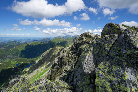 View of Tri kopy in Western Tatras with sharp rocky ridges green mountain slopes and blue sky with fluffy clouds in Ziar Zilina Region Slovakia. View of Tri kopy in Western Tatras with sharp rocky ridges green mountain slopes and blue sky with fluffy clouds in Ziar Zilina Region Slovakia.