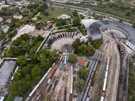 Aerial view of the Hungarian Railway Museum featuring a circular turntable with historic locomotives and railway tracks in Budapest Hungary. Aerial view of the Hungarian Railway Museum featuring a circular turntable with historic locomotives and railway tracks in Budapest Hungary.