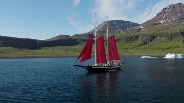 Aerial view of schooner with red sails in Greenland. Aerial view of schooner with red sails in Greenland.
