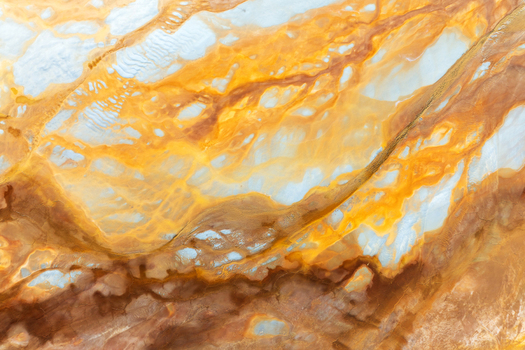 Aerial view of the abstract mineral patterns and vibrant orange sediment at the historic open pit mine Minas de Riotinto Andalusia Spain.